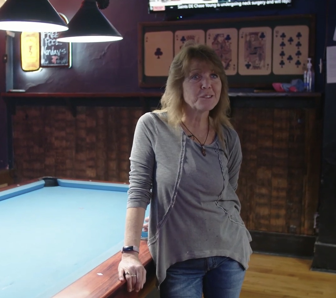 Leslie standing beside a pool table